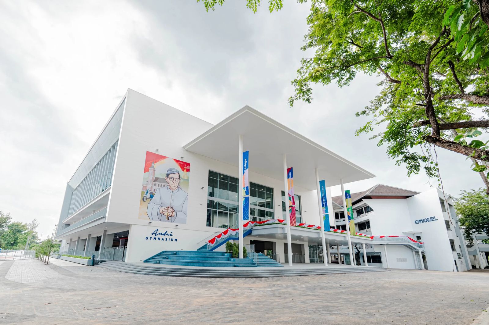 André Gymnasium at Montfort College: white walls and a deep canopy over the entrance steps
