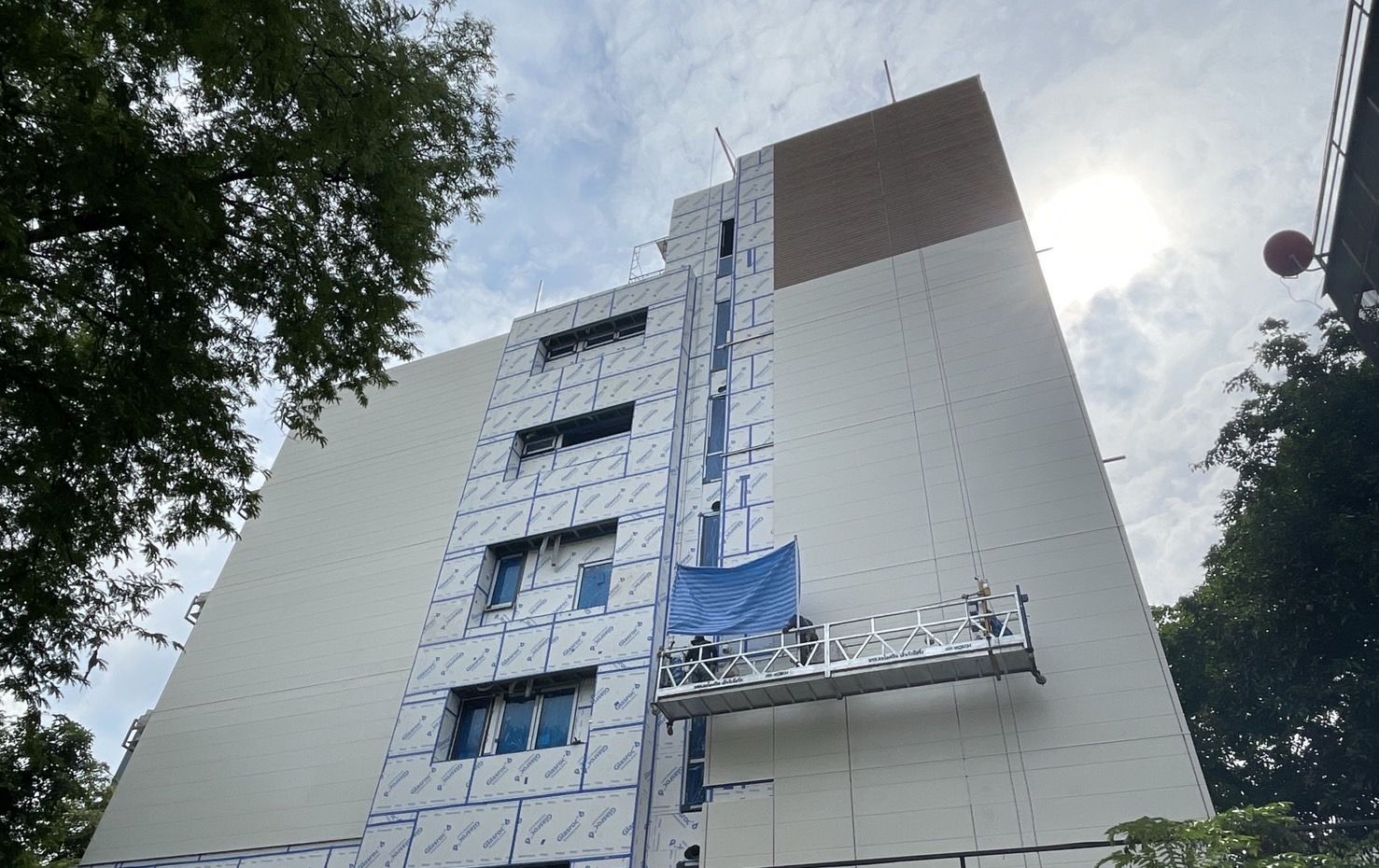 Sathorn Residence, seven storeys, under construction: Glasroc X sheathing on the facade and a crew on a gondola fixing the cladding