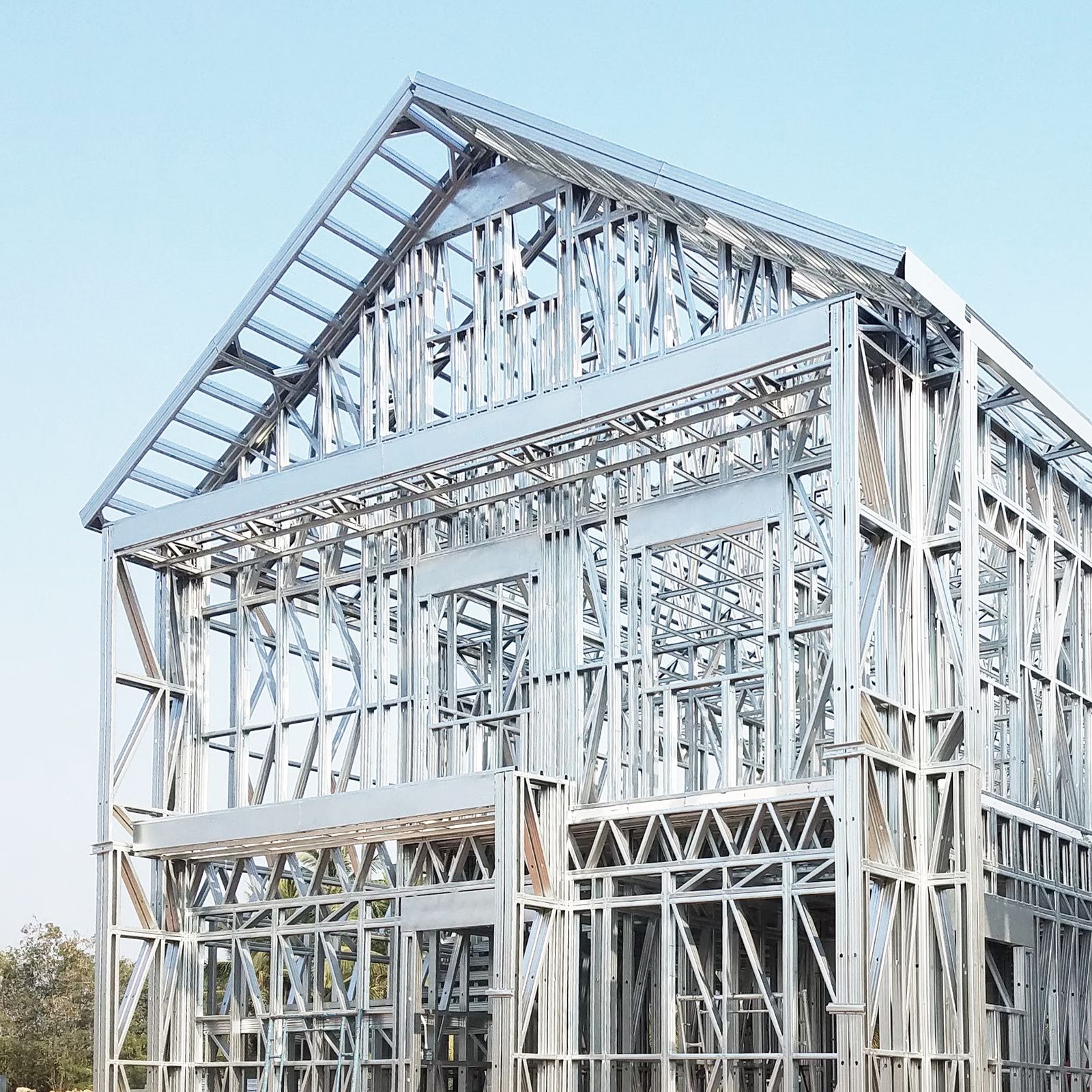 The ProFrame steel frame of a two-storey scout camp building in Nakhon Pathom, standing complete to its roof against a clear blue sky