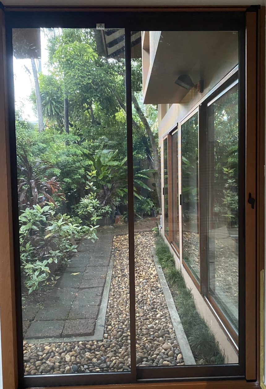 A two-panel sliding glass door onto a pebble garden, with one slim interlock between the panels